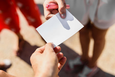 Cropped hand giving paper to person