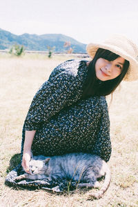 Portrait of smiling young woman sitting on field