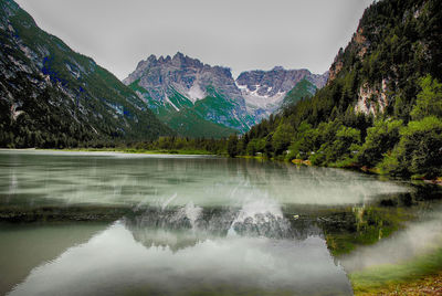 Scenic view of lake by mountains against sky