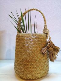 Close-up of wicker basket on table against wall