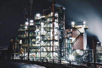 Illuminated bridge against sky at night