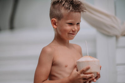 Portrait of shirtless boy drinking glass