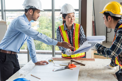 Architects preparing blueprints on desk at office