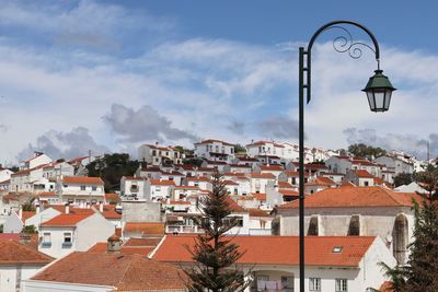 Street light and houses against sky