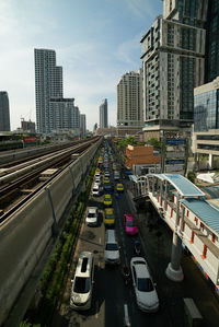 Vehicles on road in city against sky