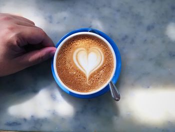 Close-up of hand holding coffee cup