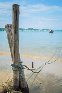 A rope of a boat is tie up with wooden stake on the beach