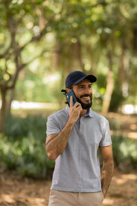 Young man at park on a beautiful sunny day with mobile phone.  working  leisure. green and nature 