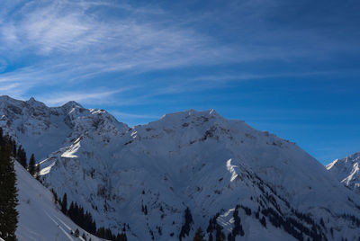 Scenic view of snowcapped mountains against blue sky