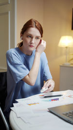 Portrait of young woman sitting on table