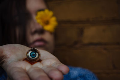 Close-up of woman holding artificial eye