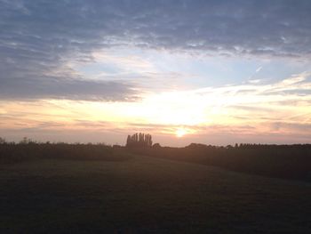 Scenic view of silhouette field against sky during sunset