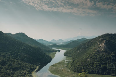 Scenic view of river amidst mountains against sky