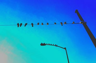Low angle view of street light against blue sky