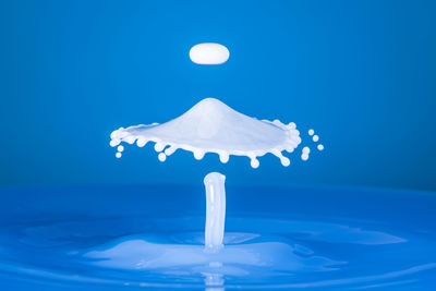 Close-up of splashing water against blue background