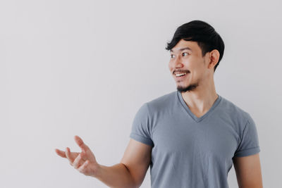 Smiling young man standing against white background