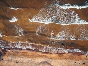High angle view of sea waves on shore at beach