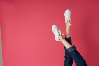 Full length of woman standing against pink background