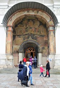 Rear view of people in front of historic building