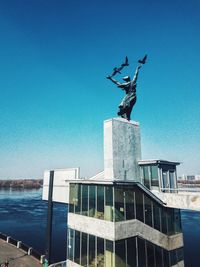 Low angle view of statue against blue sky