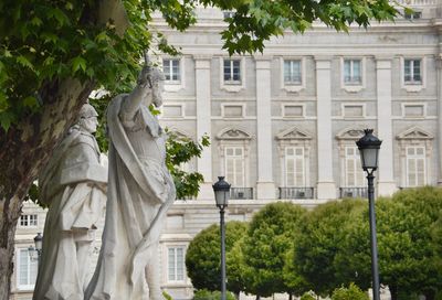 Statue by street against buildings in city