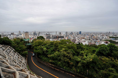 High angle view of street amidst buildings against sky