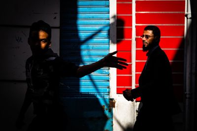 Side view of man standing against wall