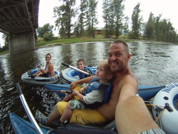 Rear view of people sitting on boat