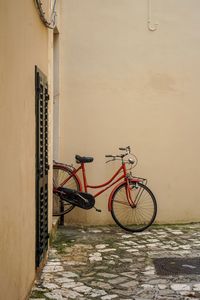 Bicycle leaning on wall of building