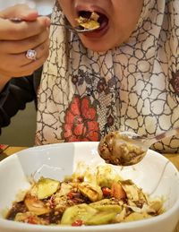 Midsection of woman having food in plate