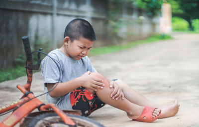 Full length of boy fell from bicycle outdoors