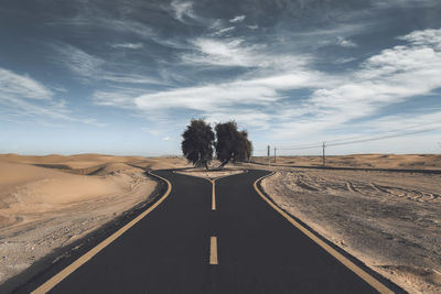 Road leading towards landscape against sky