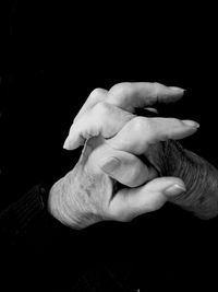 Close-up of hand holding over black background