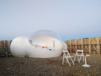 White chairs on field against clear sky
