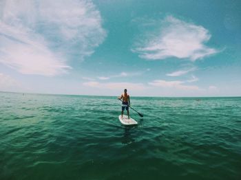 Man fishing in sea against sky