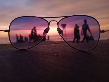 Silhouette of people in front of sea during sunset