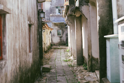 Footpath amidst buildings in city