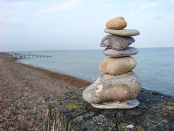 Stack of stones on beach against sky