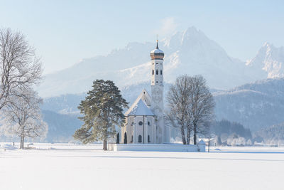 View of snow covered landscape with buildings in background