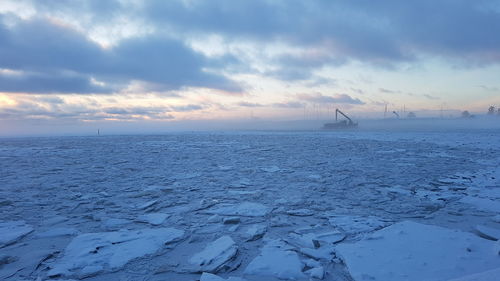 Scenic view of frozen sea against cloudy sky