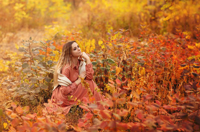 Woman sitting on plant during autumn