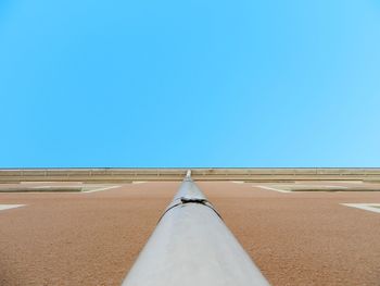 Tilt image of sand against clear blue sky