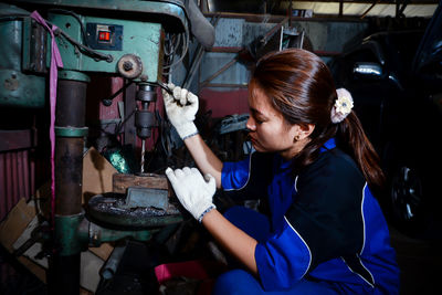 Portrait of young woman sitting in factory