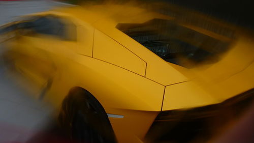 Blurred motion of yellow car on street