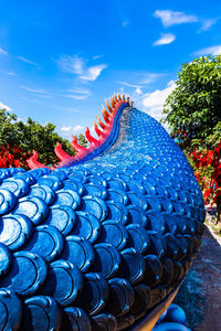 Close-up of multi colored umbrellas against blue sky