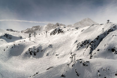 Scenic view of snowcapped mountains against cloudy sky