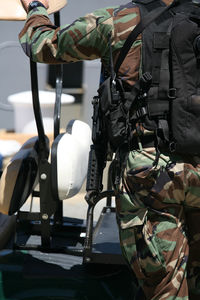 Midsection of soldier on vehicle