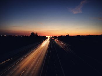 Road passing through illuminated tunnel