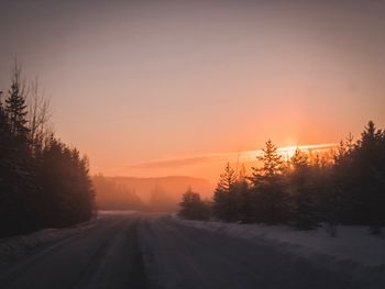 Scenic view of snow covered landscape against sky during sunset