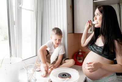 Happy mother and son on table